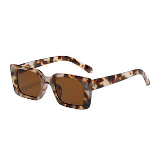 A person wearing oversized square frame sunglasses with a classic tortoise pattern.