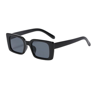 A person wearing oversized square frame sunglasses with a classic tortoise pattern.