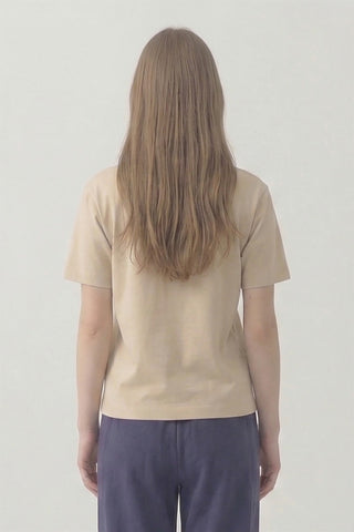 Person wearing a beige t-shirt and purple pants against a plain background