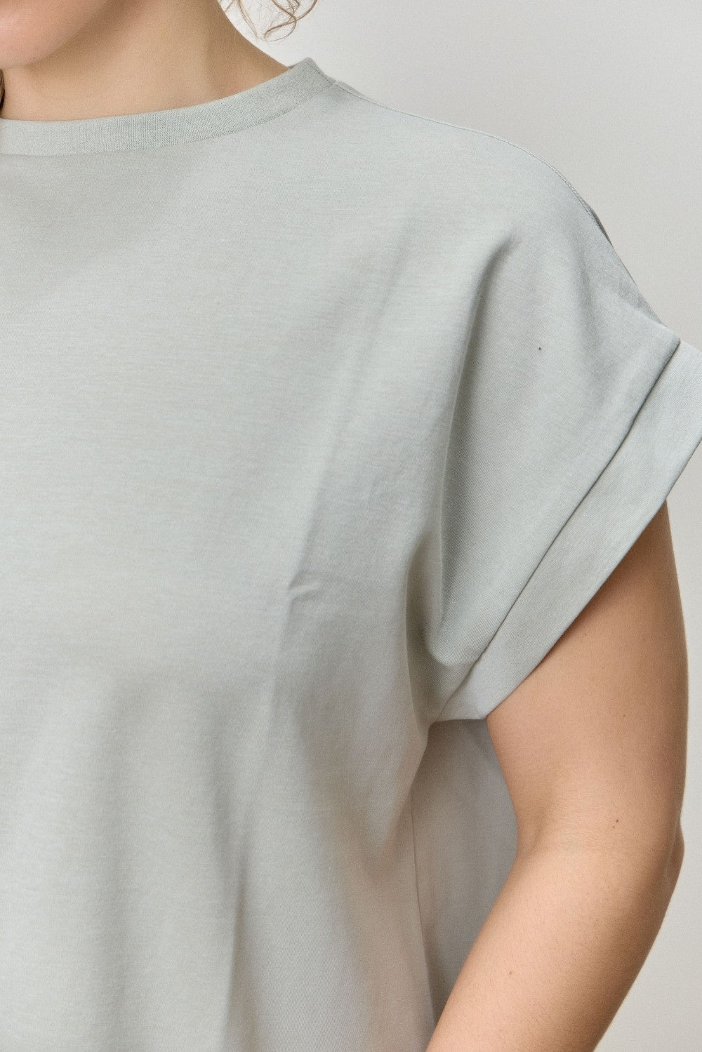 Light gray t-shirt worn by a person on a plain background