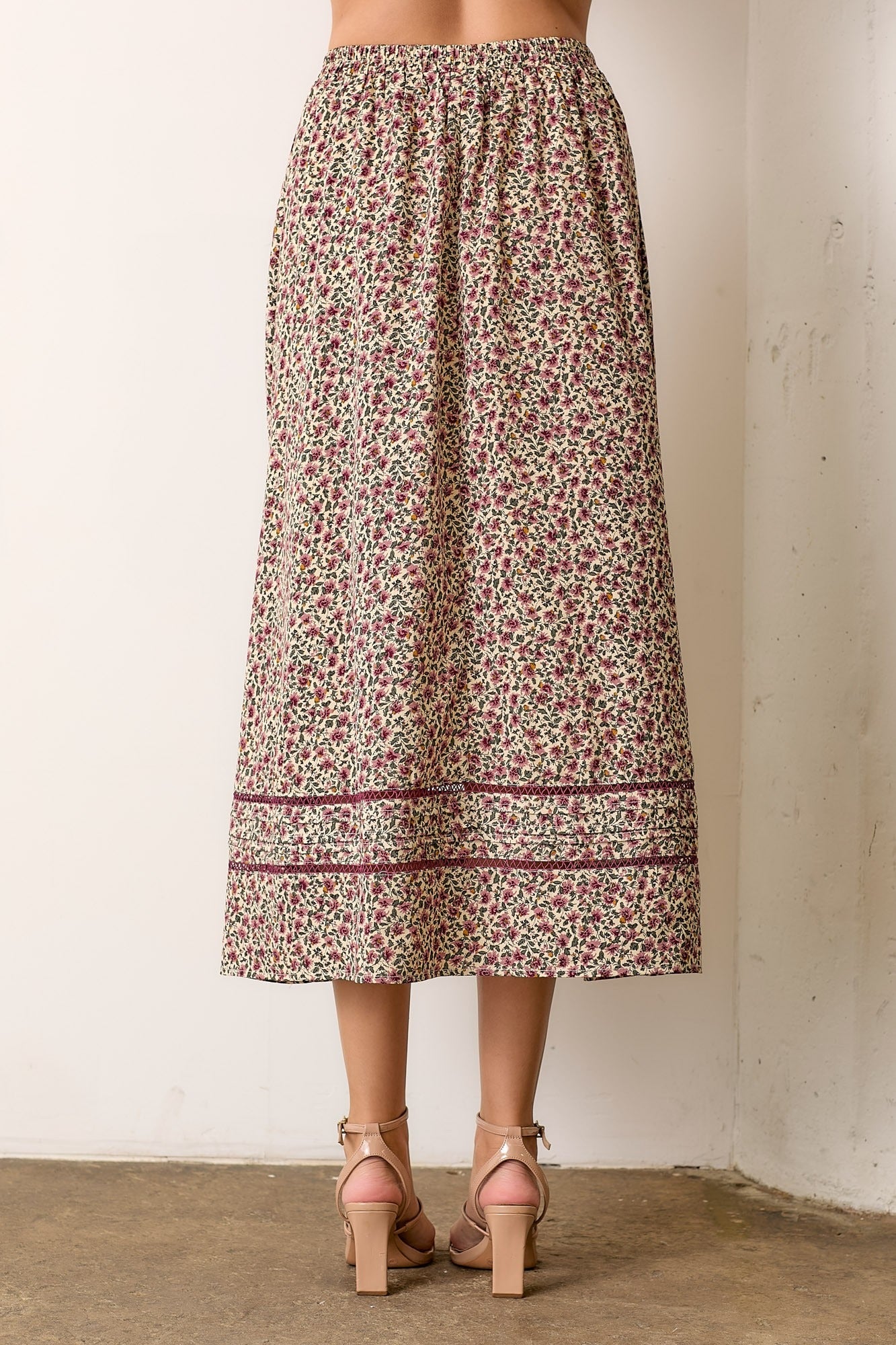 Floral patterned skirt worn by a person against a plain background
