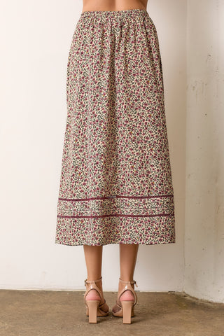 Floral patterned skirt worn by a person against a plain background