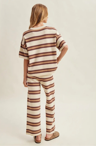 Women wearing a striped matching set against a neutral background.