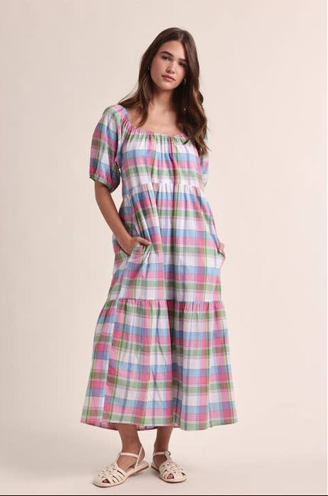 Woman wearing a plaid dress on a plain background
