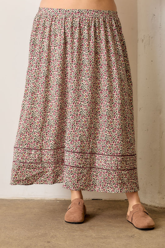 Person wearing a floral skirt with a neutral background