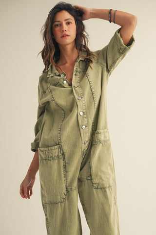 Woman wearing a green jumpsuit against a plain background