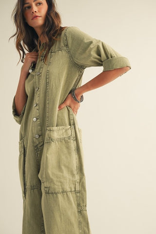 Woman wearing a green jumpsuit against a plain background