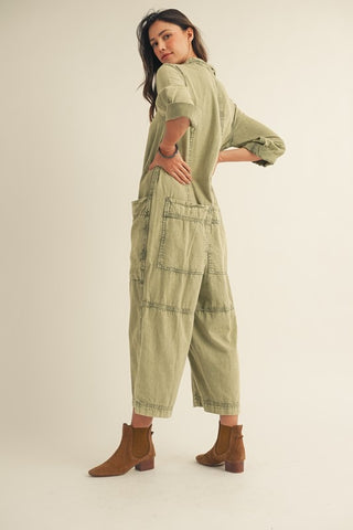 Woman wearing a green jumpsuit on a plain background