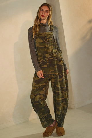 Person wearing a camouflage overalls with a plain background
