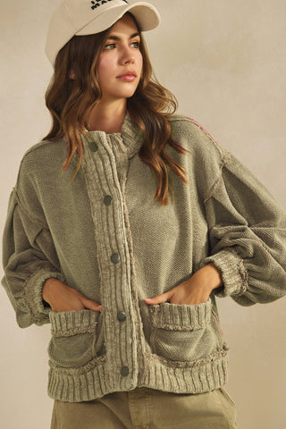 Woman wearing a green cardigan with button details on a beige background