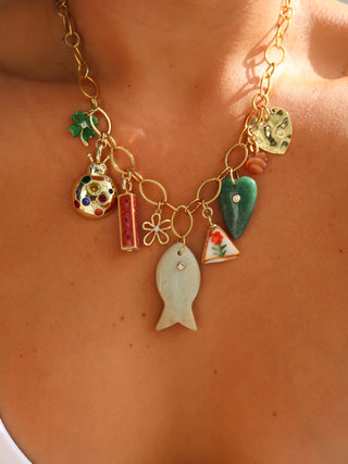 Necklace with various charms on a person's neck