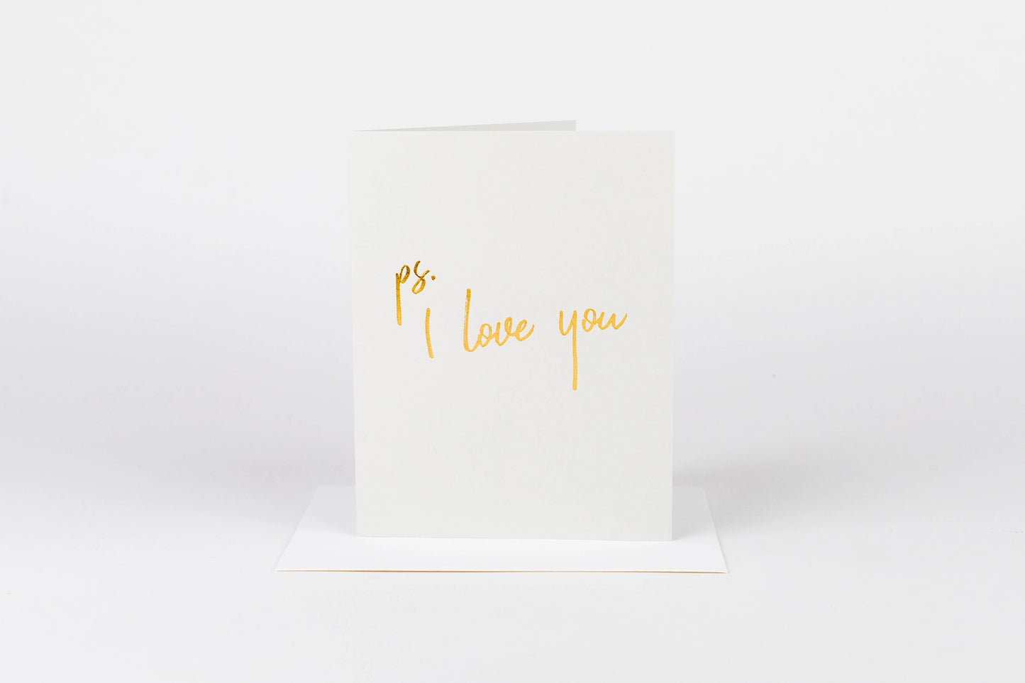 White card with 'ps. I love you' text in gold on a white background