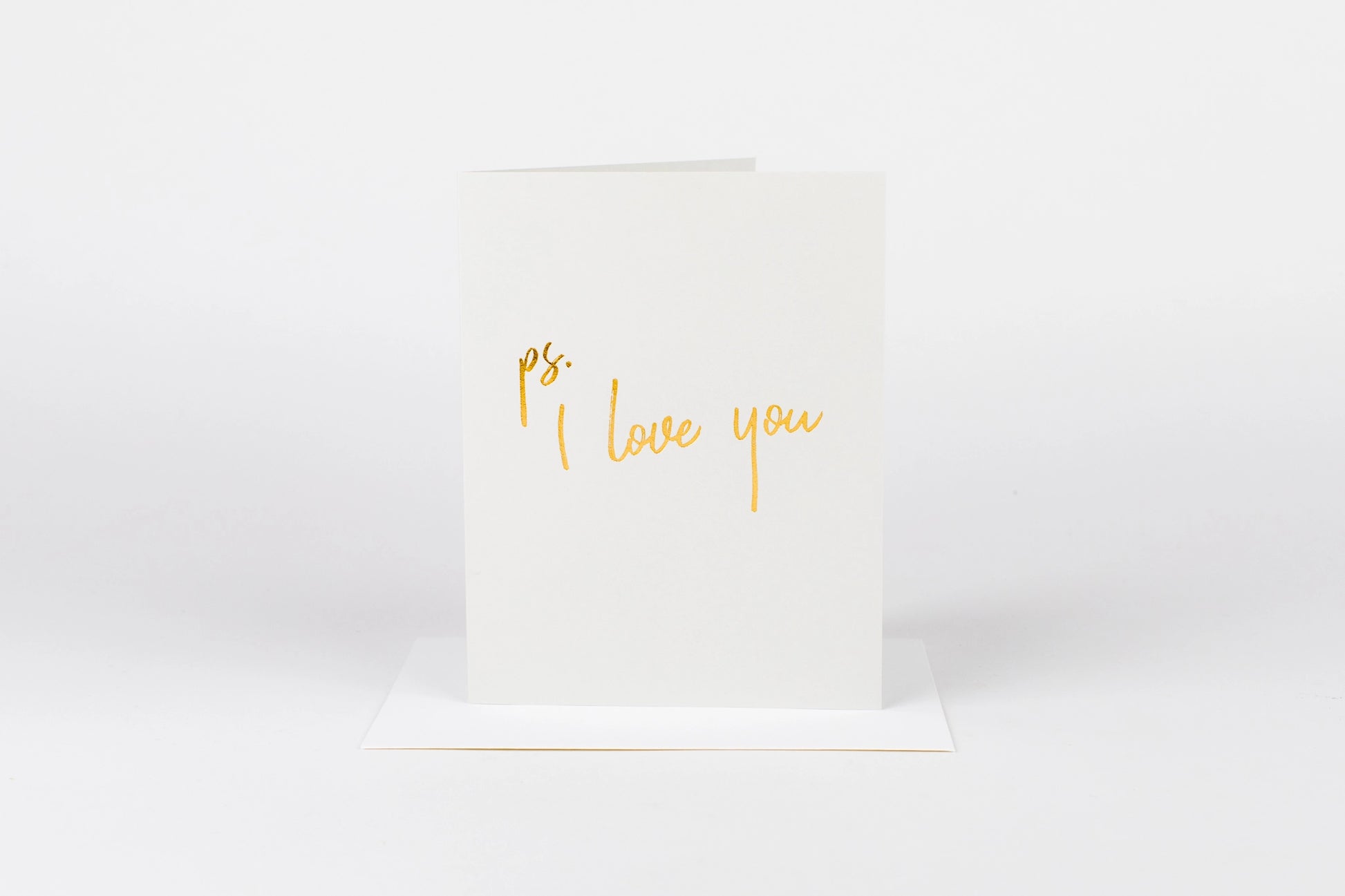 White card with 'ps. I love you' text in gold on a white background