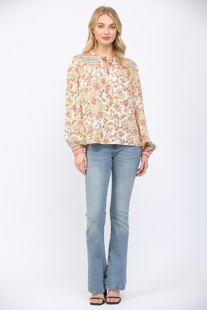 Women wearing a floral print blouse and blue jeans on a white background.