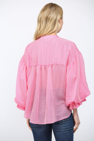 Women wearing a pink striped button up blouse on a white background.