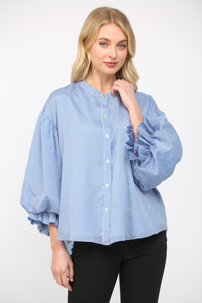 Women wearing a blue stripe blouse with black jeans on a white background.