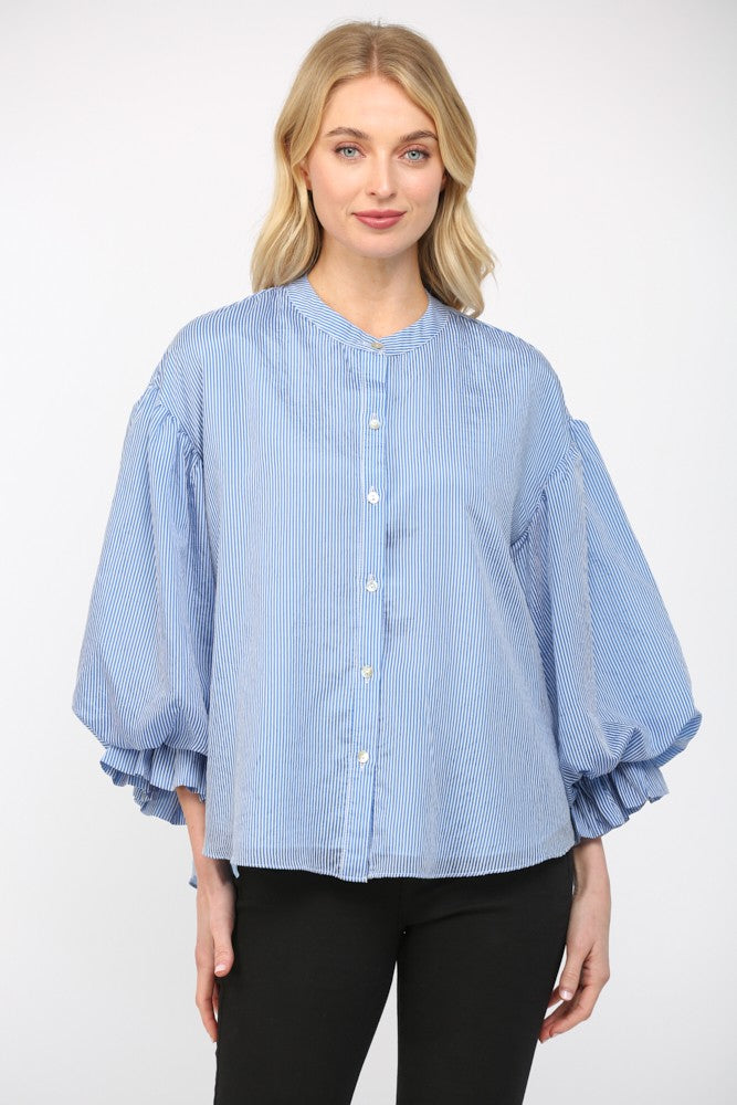Women wearing a blue stripe blouse with black jeans on a white background.