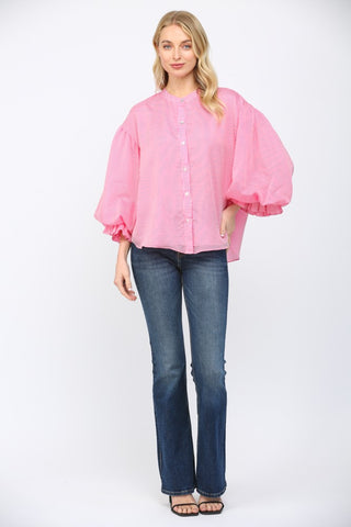 Women wearing a pink striped button up blouse on a white background.