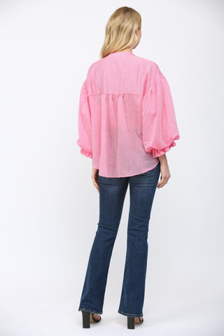 Women wearing a pink striped button up blouse on a white background.