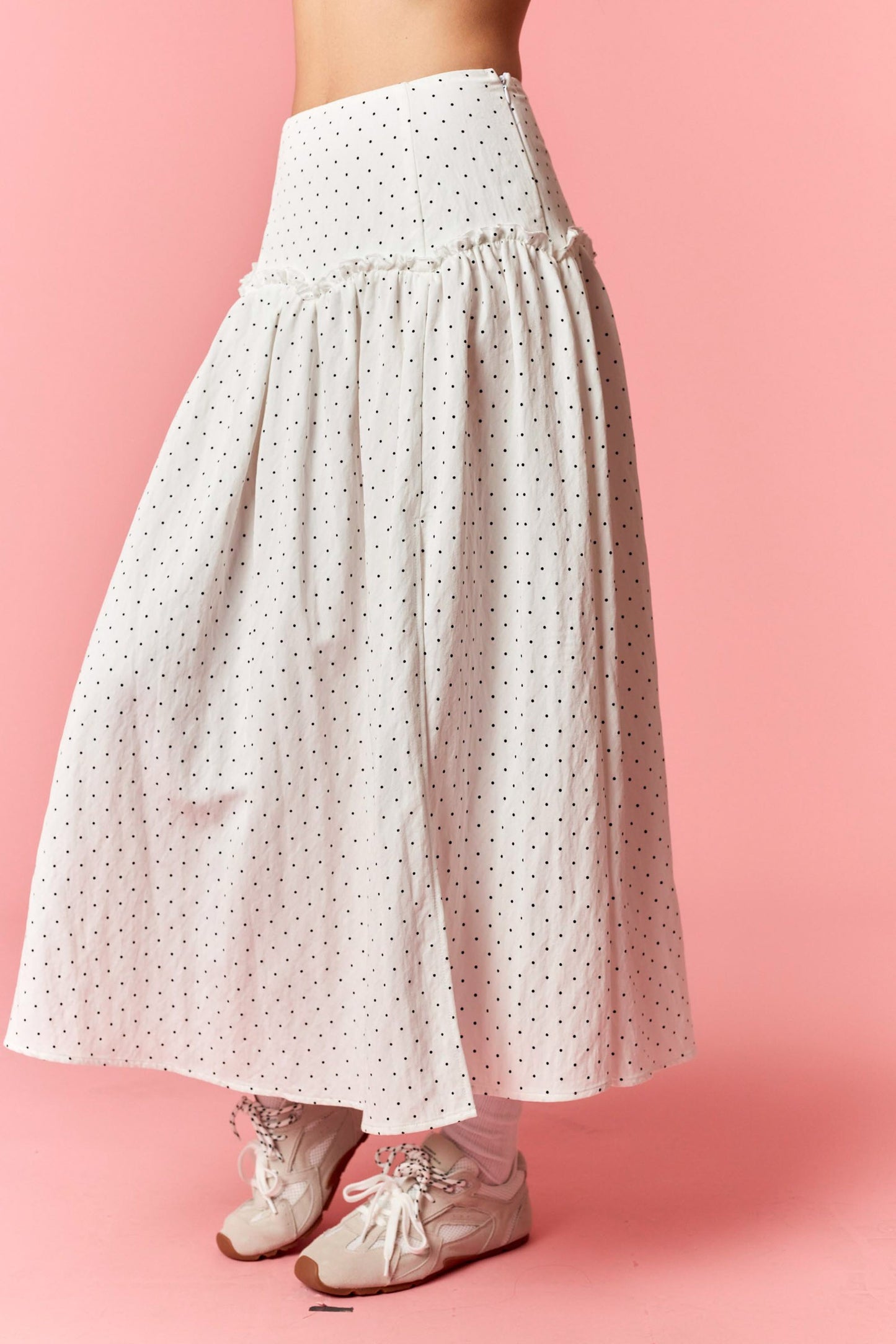 White polka dot skirt on a pink background