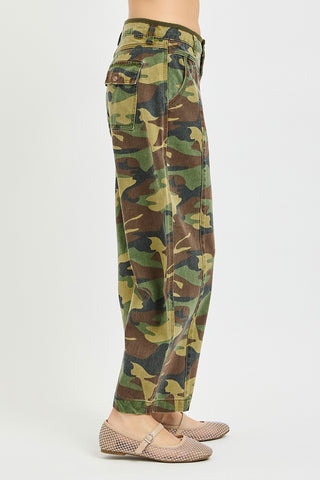 Camouflage pants worn by a person on a white background