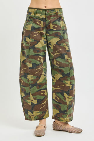Camouflage pants worn by a person on a white background
