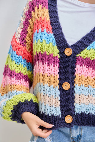 Colorful striped cardigan with buttons on a plain background