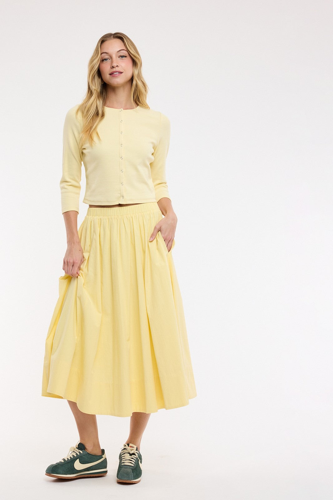 Woman wearing a yellow outfit with a white background