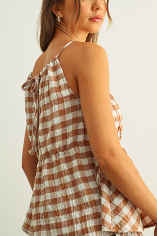 Woman wearing a checkered dress with a plain background