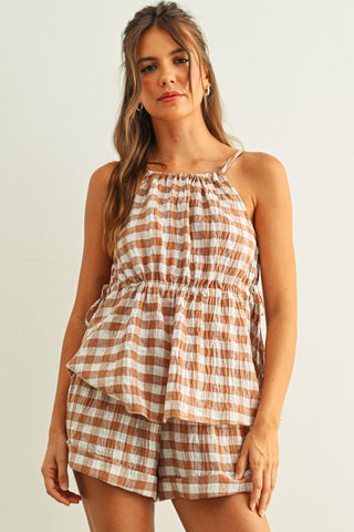 Woman wearing a plaid top and shorts set on a plain background