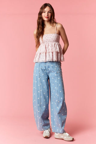 Women wearing a polka dot barrel jean on a pink background.