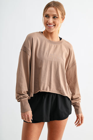 Woman wearing a beige sweater and black skirt on a white background