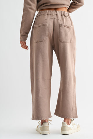 Person wearing beige high-waisted pants on a white background