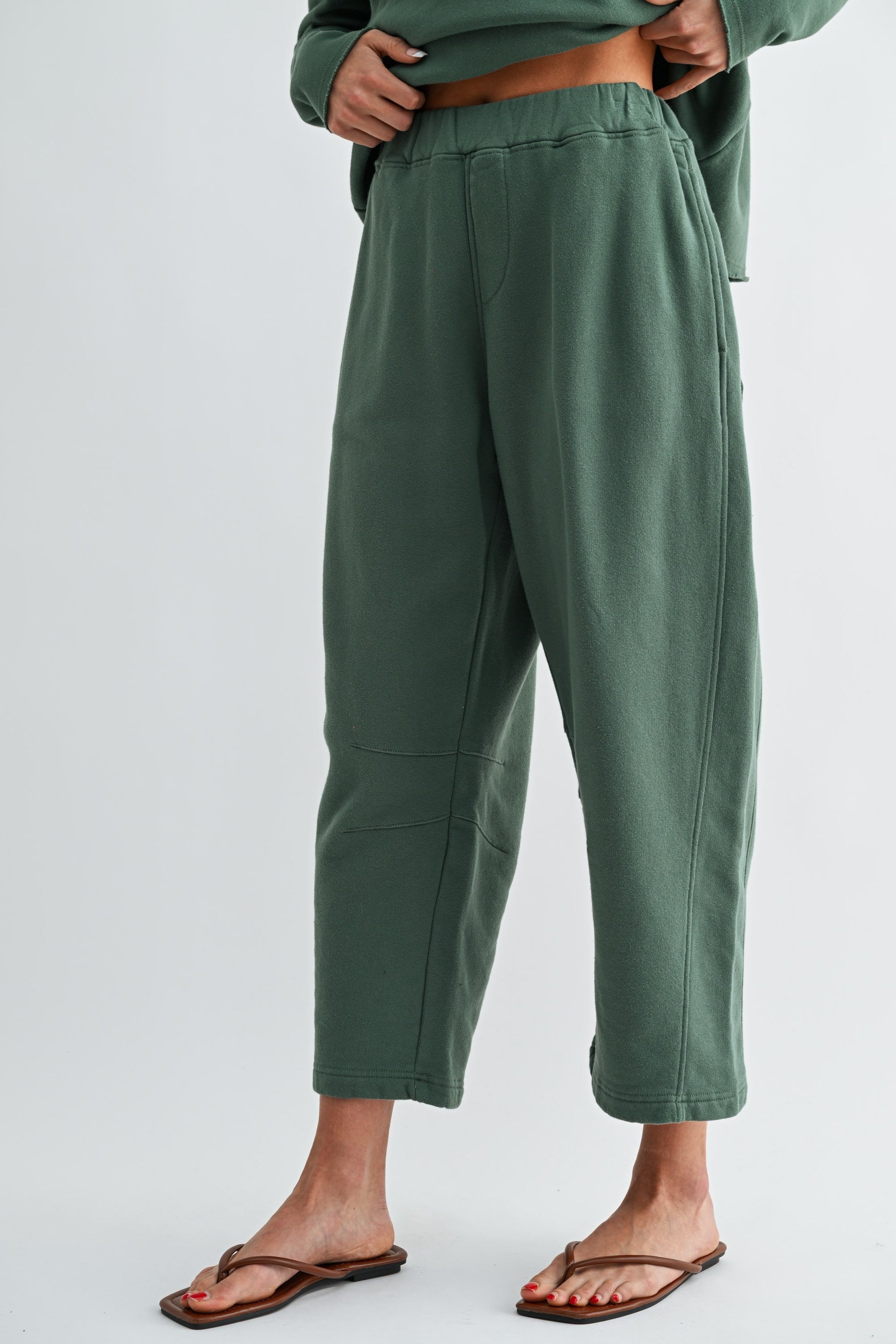 Green pants worn by a person on a light gray background
