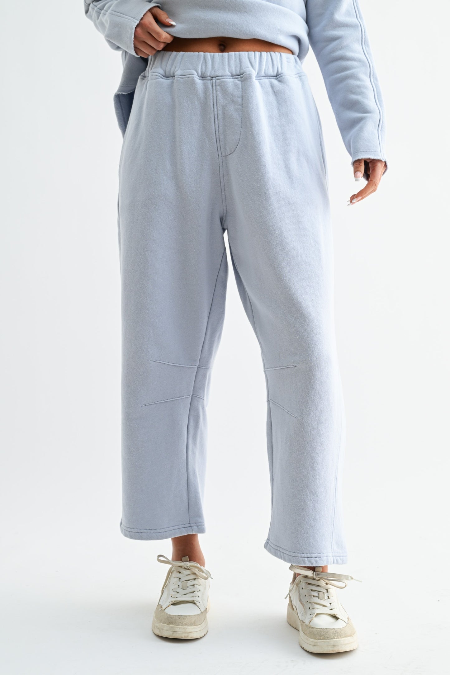 Light gray sweatpants worn by a person on a white background