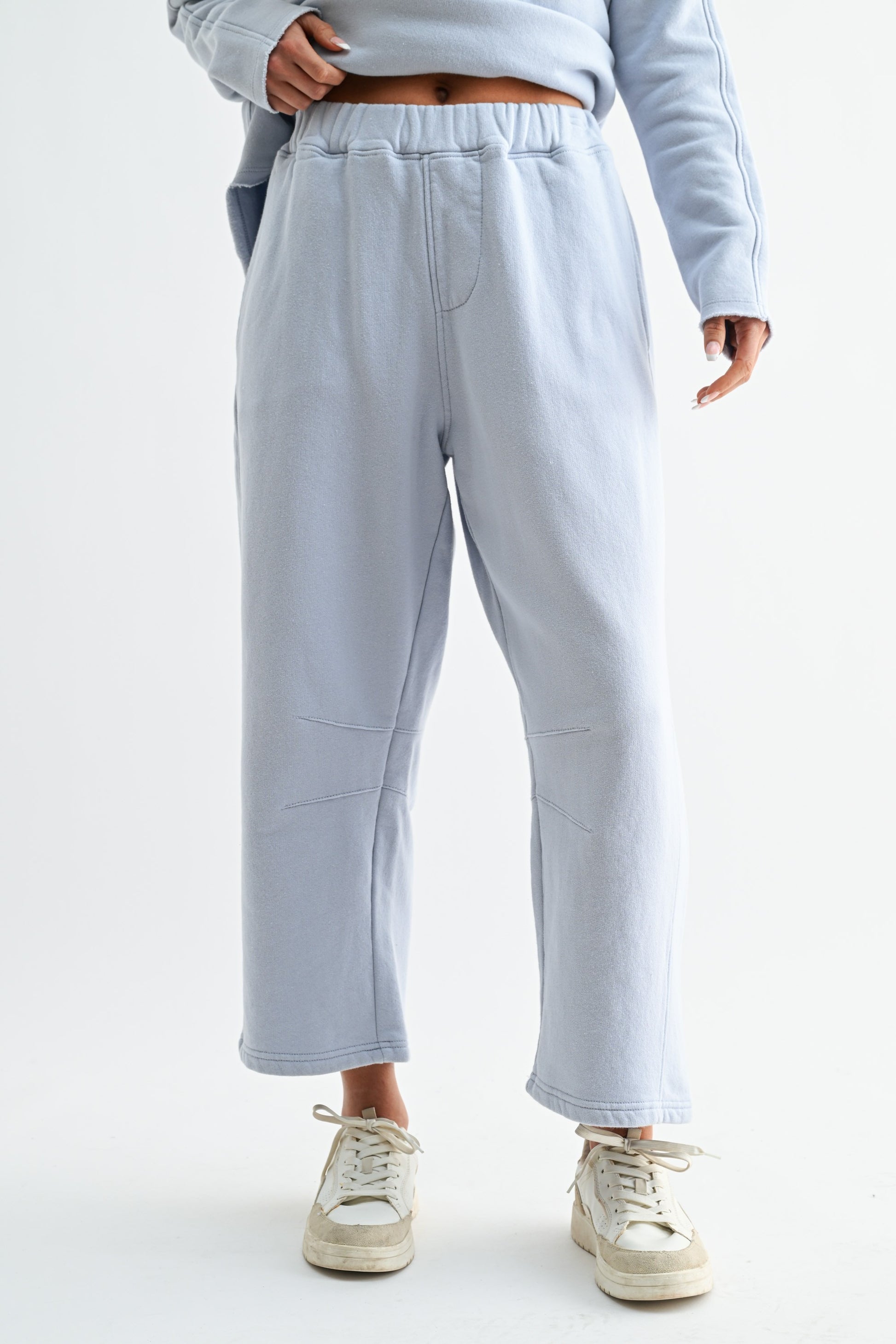 Light gray sweatpants worn by a person on a white background