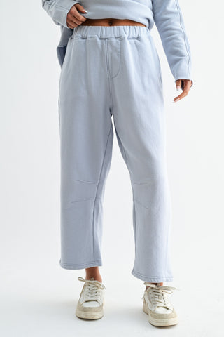 Light gray sweatpants worn by a person on a white background