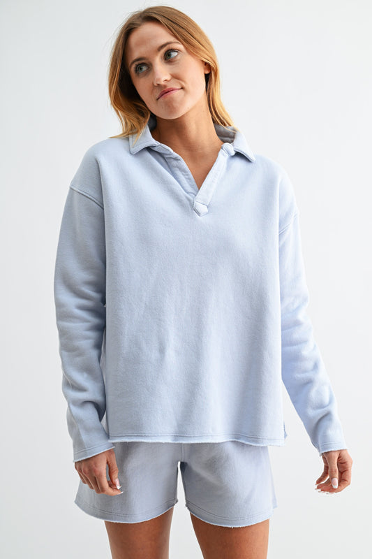 Woman wearing a light blue sweatshirt and shorts set on a white background