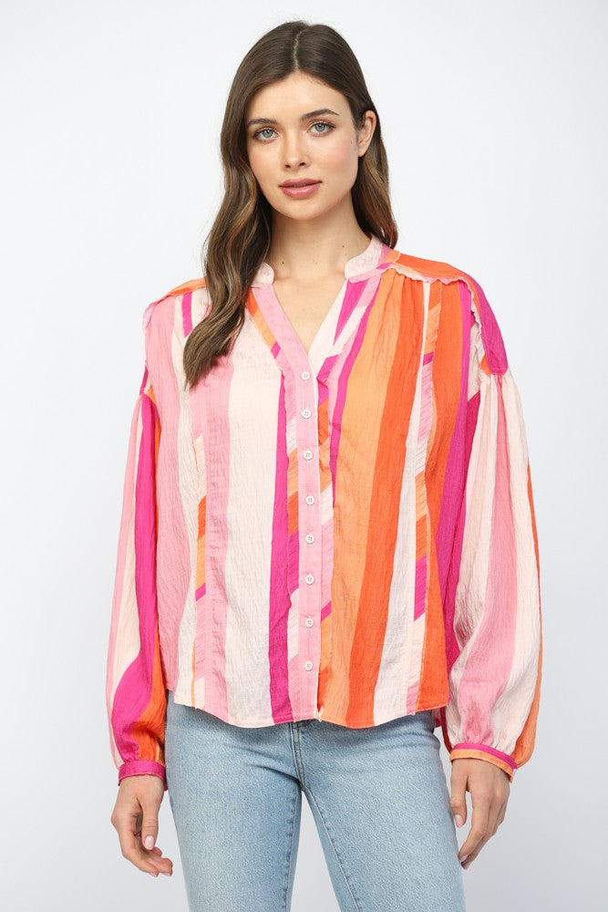 Women wearing a pink and orange stripe button up blouse with blue jeans.