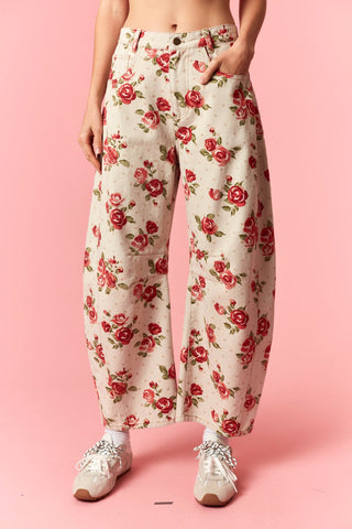 Floral pants worn by a person on a pink background