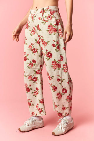 Floral pants worn by a person on a pink background