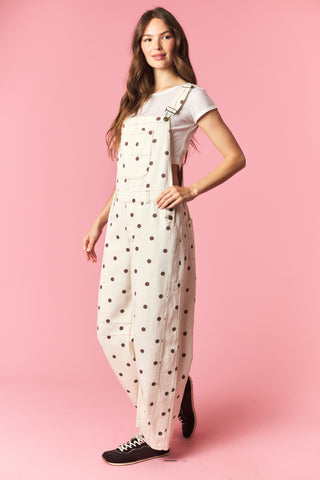 Woman wearing a polka dot jumpsuit on a pink background
