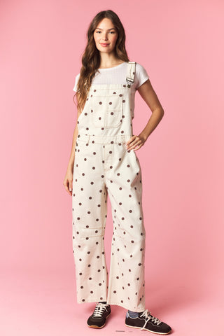 Woman wearing a polka dot jumpsuit on a pink background