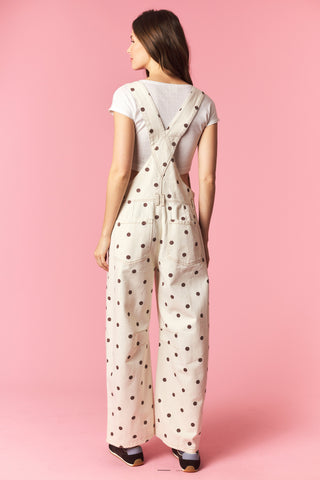 Woman wearing a polka dot jumpsuit on a pink background