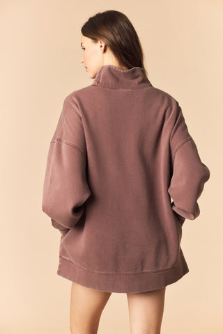 Person wearing a brown jacket on a beige background