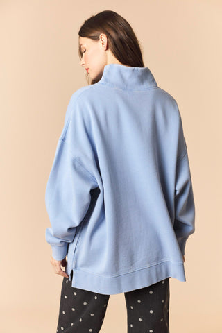 Woman wearing a light blue sweater on a beige background