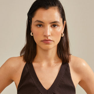 Woman wearing a black sleeveless top against a neutral background