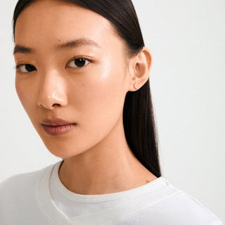 Close-up of a person with a neutral expression on a plain background