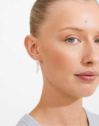 Close-up of a woman wearing a silver earring on a white background