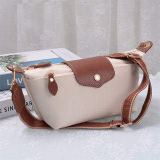 Beige handbag with brown leather accents on a light gray surface
